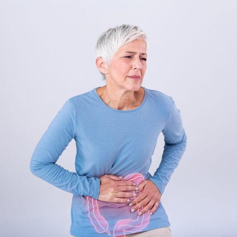 The photo of large intestine is on the senior woman body against gray background, People With Stomach ache problem concept, Female anatomy