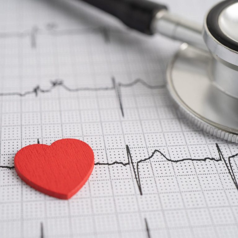 Stethoscope on electrocardiogram ECG with red heart, heart wave,