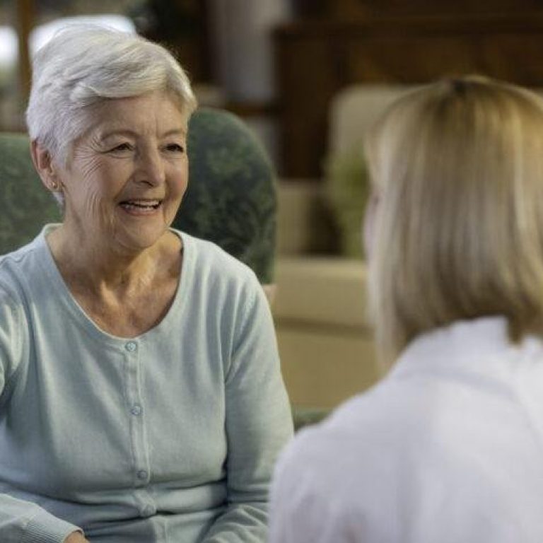 Portrait of smiling senior woman talking with female doctor