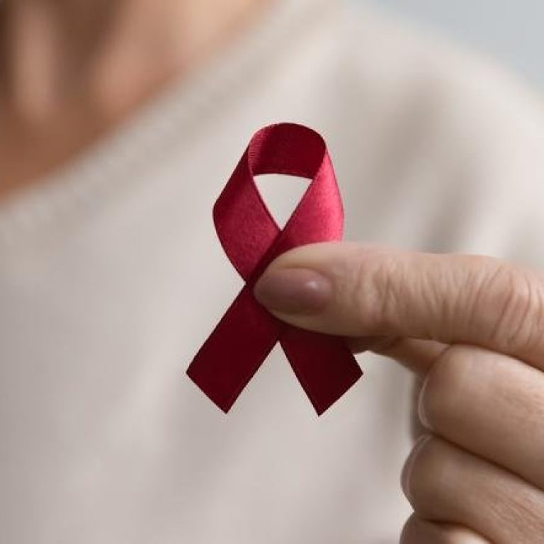 Lady showing hiv or aids awareness symbol, volunteering for charity