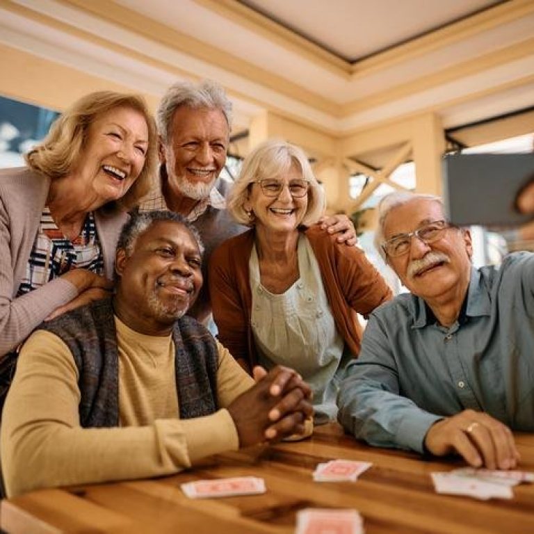 Cheerful senior having fun while taking selfie at retirement community.