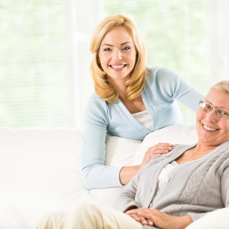 Portrait of smiling adult daughter and her senior mother